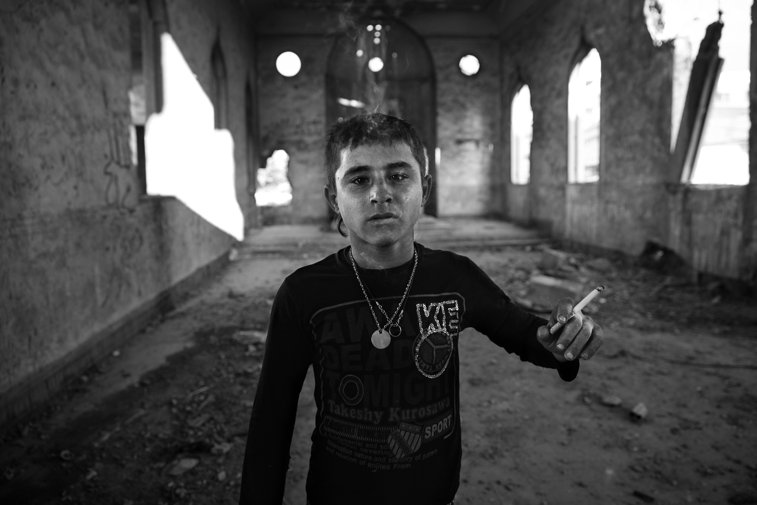 Hussem, 14 ans, pose dans le hall principal de l'école abandonnée. (photo Baudouin Nach/8e étage)