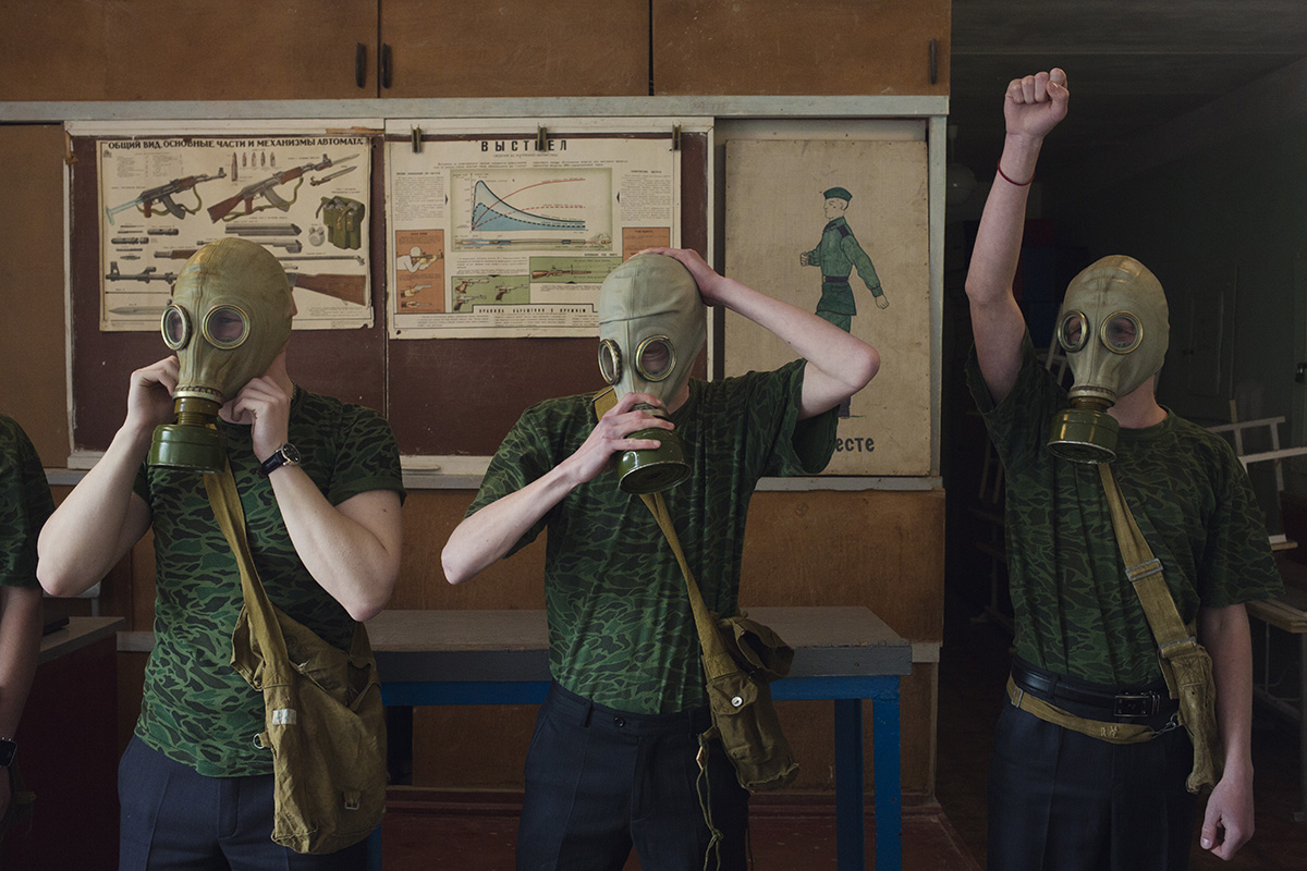 Pendant les entrainements militaires à l’école n°58, les élèves les plus âgés apprennent à mettre un masque à gaz, à lancer des grenades et à se servir d’une AK-47. (photo Kyrre Lien/8e étage)